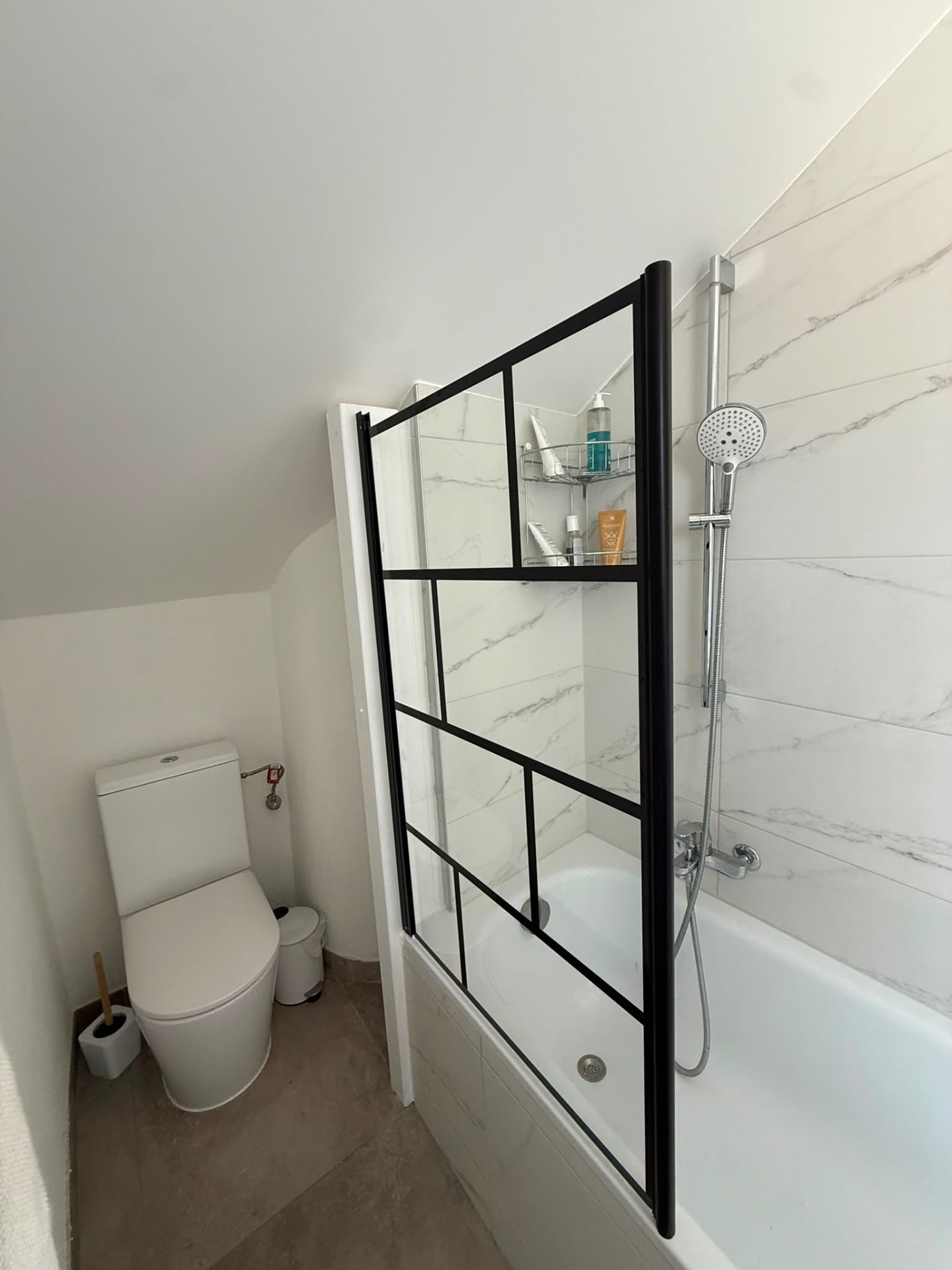 Paroi de douche style verrière atelier sur baignoire dans une salle de bain rénovée à Lausanne