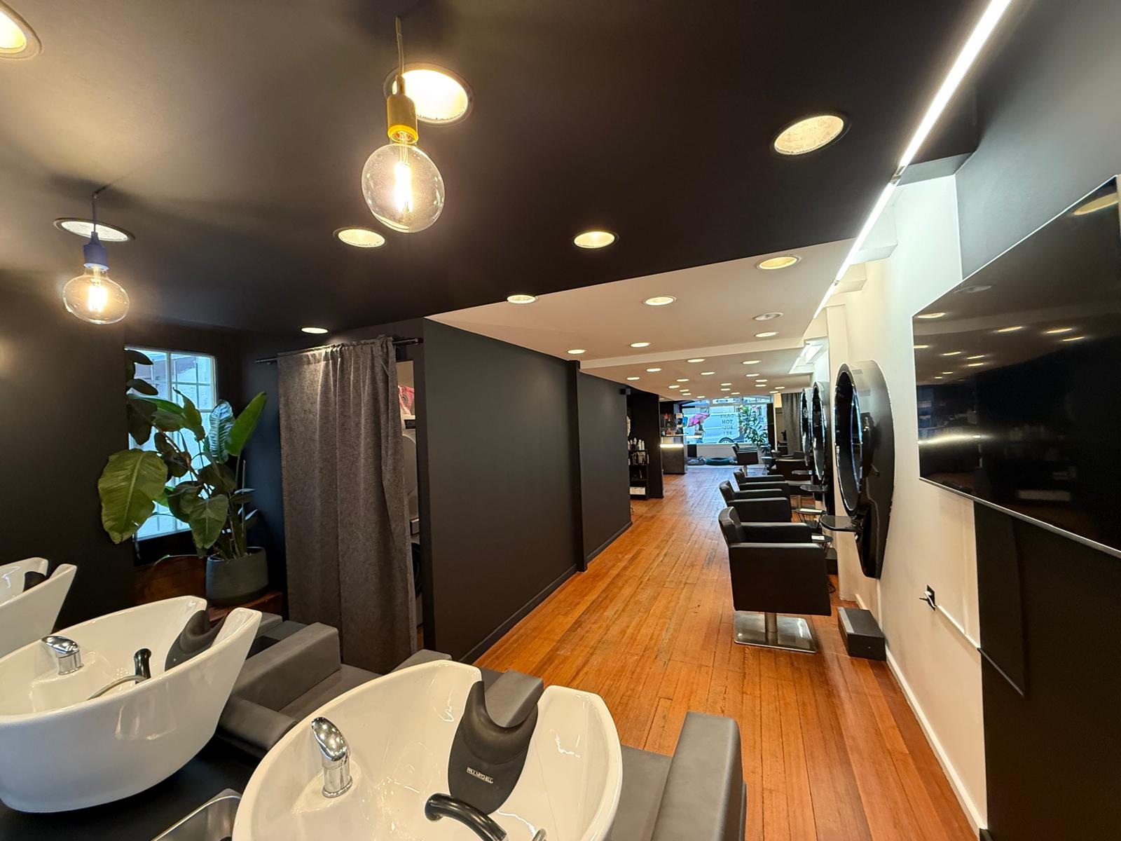 Espace bacs de lavage du salon de coiffure à Vevey avec murs et plafond noir mat