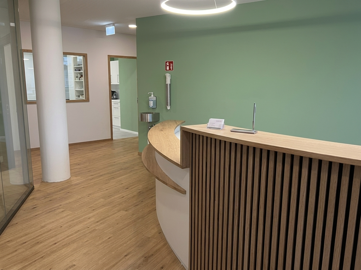 Réception du cabinet médical avec comptoir en bois cintré et mur vert d'eau — Écublens