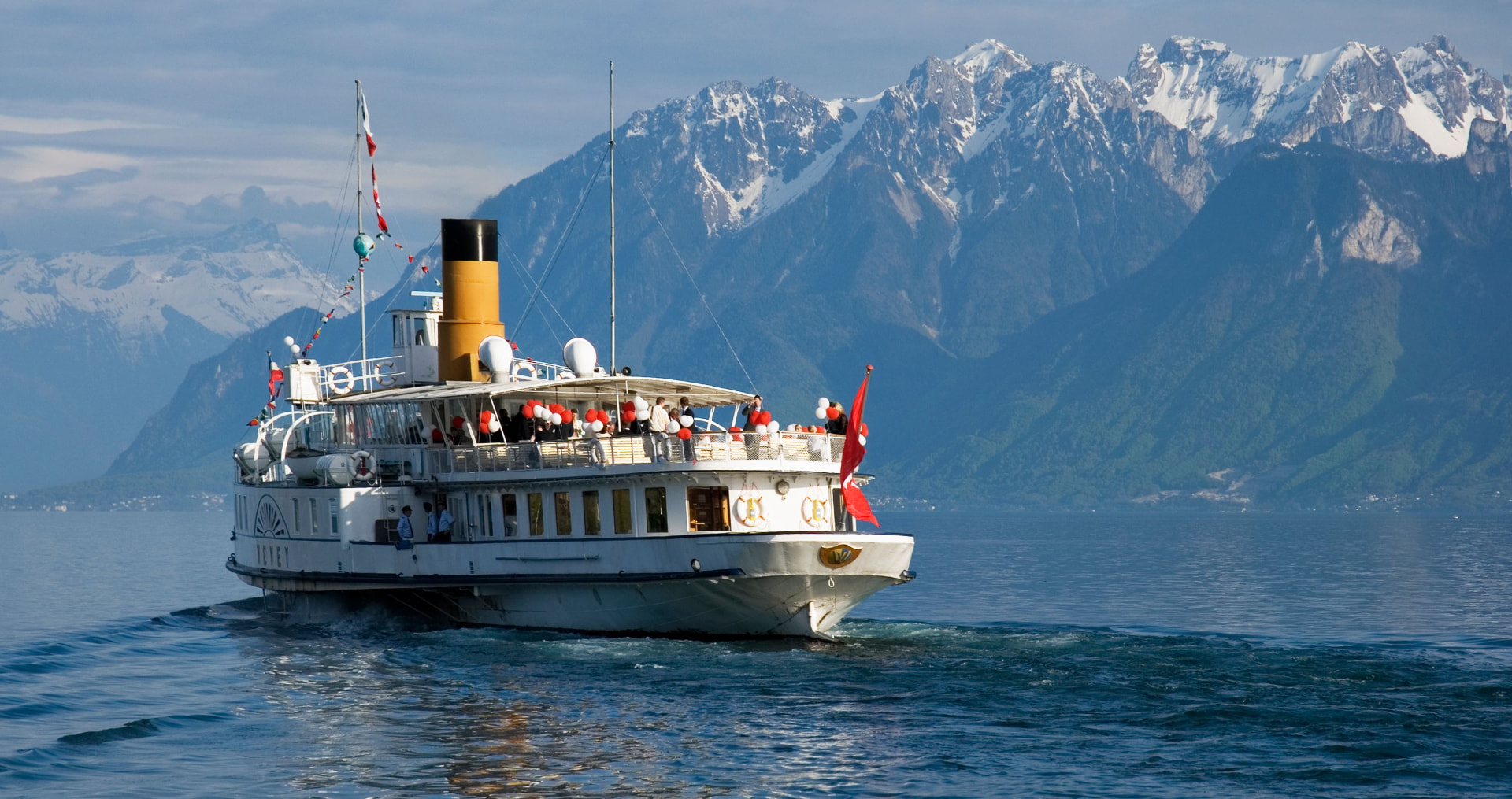 Bateau à vapeur sur le Léman avec les Alpes enneigées, symbole de la Suisse romande